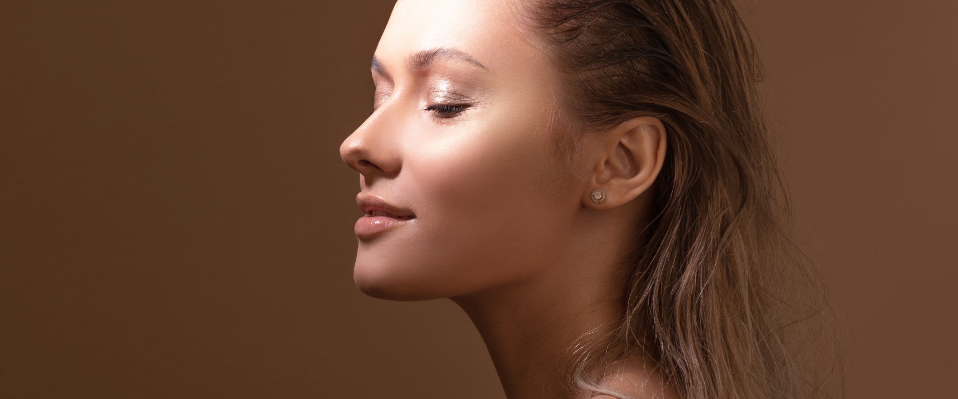 femme maquillée naturellement qui montre sa peau sur un fond neutre