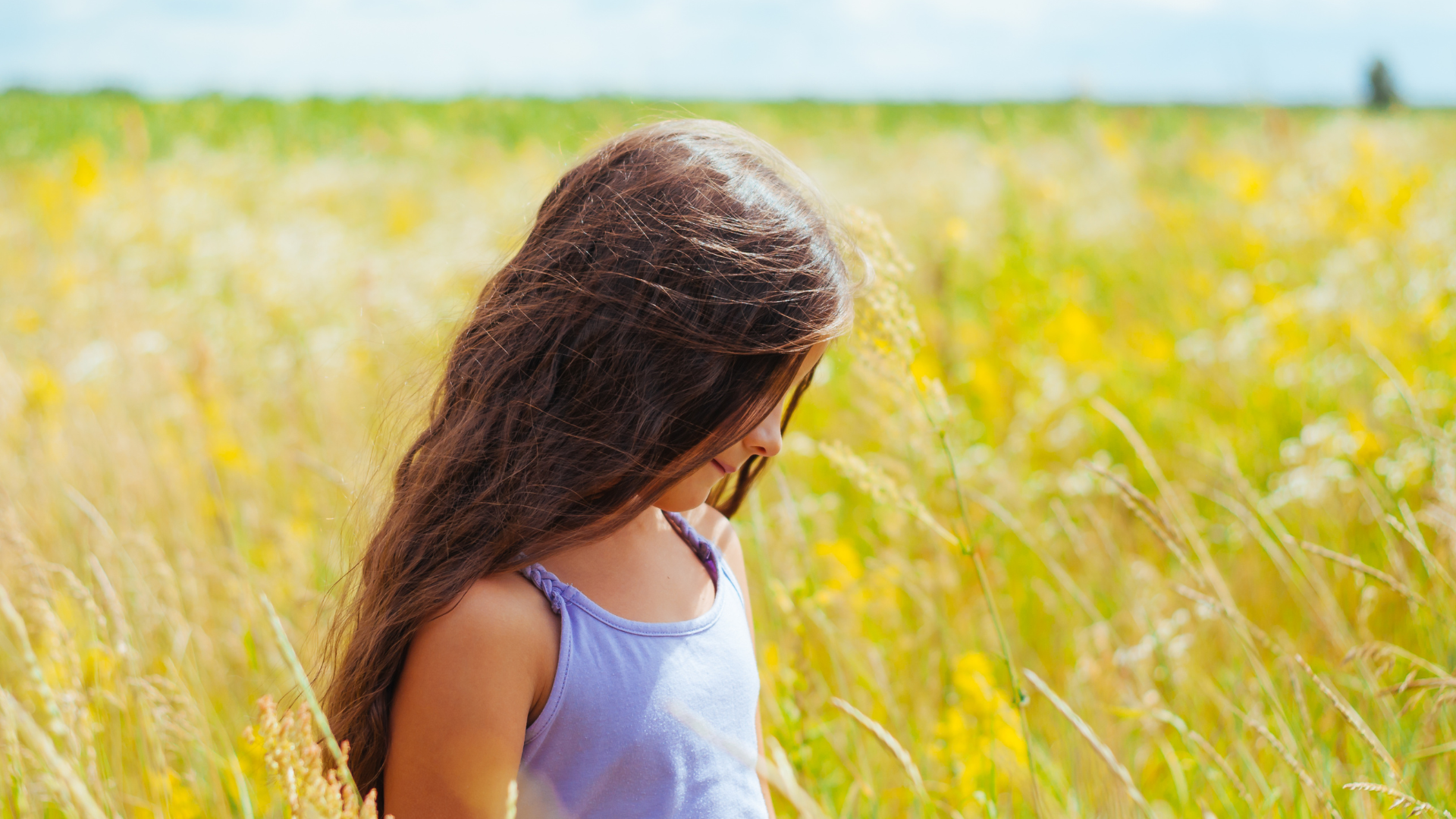 enfant fille dans un champs qui évoque la nature et la simplicité