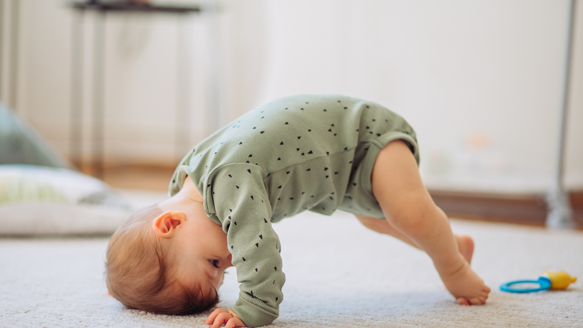 bébé qui se tient à quatre pattes sur un tapis
